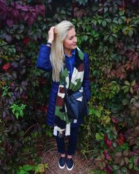 Smiling girl standing by flower plants