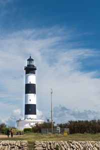 Lighthouse on landscape against sky