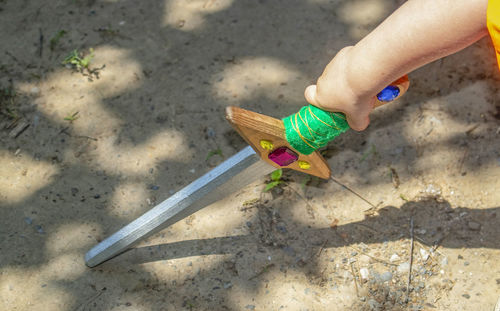 Cropped hand holding toy sword