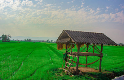 Barn on field against sky