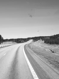 Empty road by landscape against sky