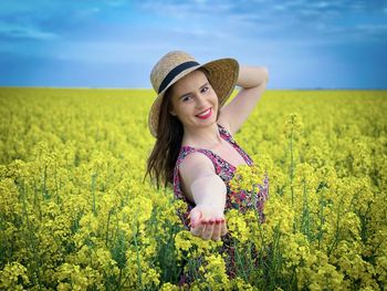 Beautiful young woman with yellow flowers in field