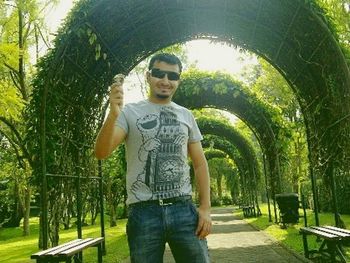 Portrait of boy wearing sunglasses standing against trees