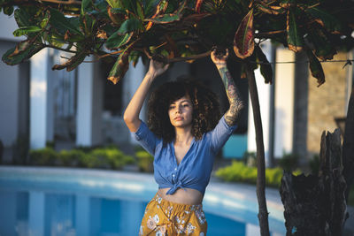 Young woman standing against swimming pool