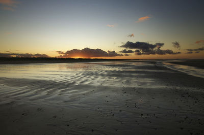 Scenic view of beach against sky during sunset