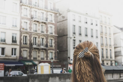 Rear view of woman in front of buildings