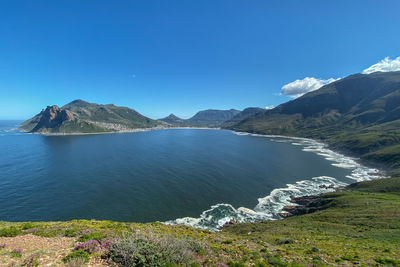 Scenic view of lake and mountains against clear blue sky