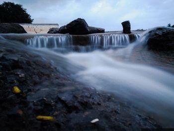 Scenic view of waterfall against sky