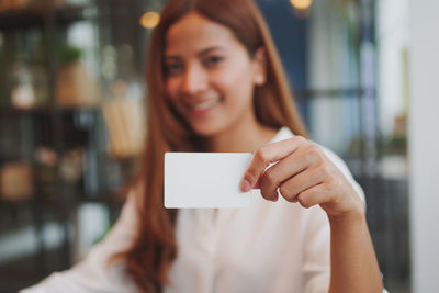 Businesswoman showing paper while sitting in cafe