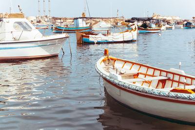 Boats moored on lake against sky