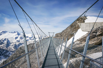 Empty titlis cliff walk by mountains against sky