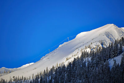 Scenic view of snowcapped mountains against blue sky