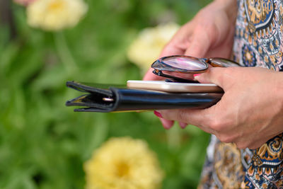 Midsection of woman holding personal accessories