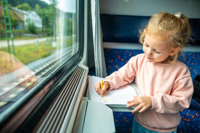 Side view of boy looking through window