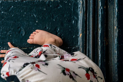 Low section of man resting on bed