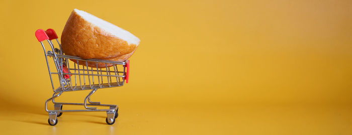 Close-up of cake on table against orange background