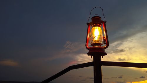 Low angle view of illuminated light against sky during sunset