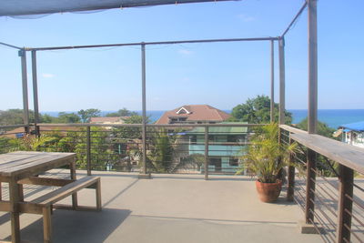 Built structure by sea against clear sky on sunny day