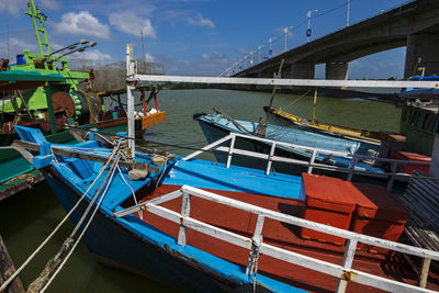 Fishing boats moored in sea against sky