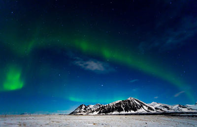 Scenic view of snowcapped mountains against sky at night