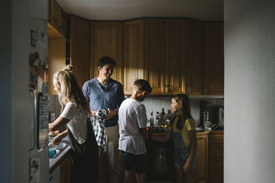 Happy family doing chores in kitchen at home