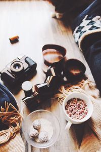 High angle view of camera and reel by food on wooden table