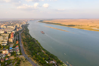 High angle view of road by sea and buildings against sky