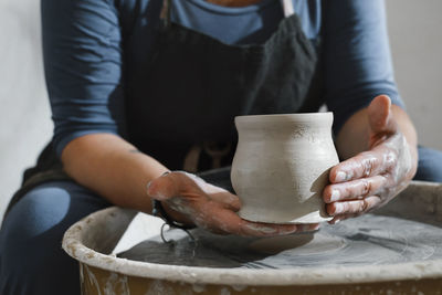 Potter making bowl on wheel. self-employed pottery artist in creative studio working with raw clay