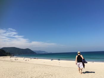 Woman on beach against sky