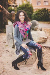 Portrait of smiling young woman sitting on logs
