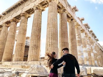 Low angle view of people standing at historical building