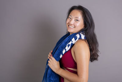 Portrait of young woman standing against wall