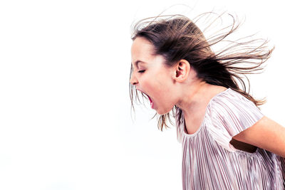 Side view of girl shouting against white background