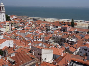 High angle view of townscape by sea against sky