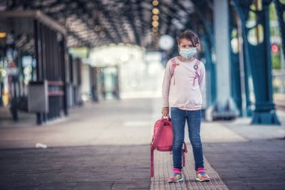 Portrait of woman standing on footpath