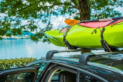 Kayak on car against lake