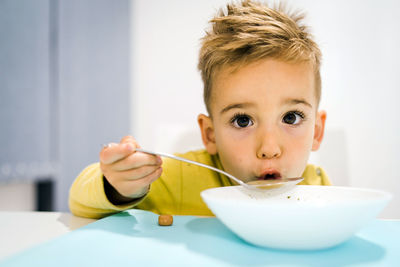 Close-up of boy eating soup at home