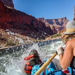 Close-up of woman rafting in river by grand canyon