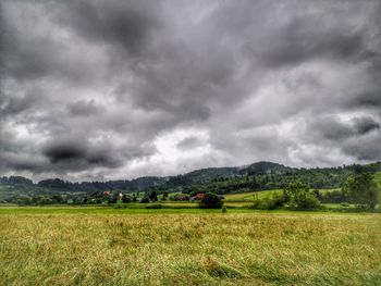 Scenic view of field against cloudy sky