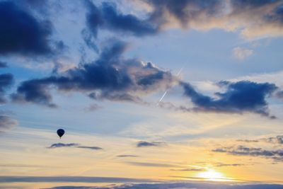 Hot air balloon flying against sky during sunset