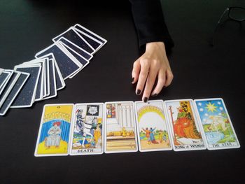 Fortune teller sitting in front of tarot cards on table