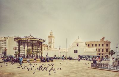 Group of people in front of historic building against sky