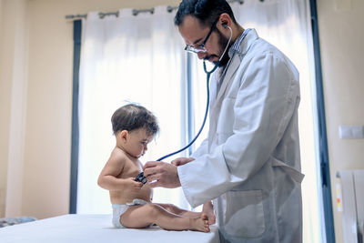 Doctor observing a one-year-old baby