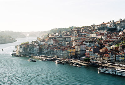 High angle view of townscape by sea against clear sky