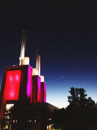 Low angle view of illuminated building against sky at night