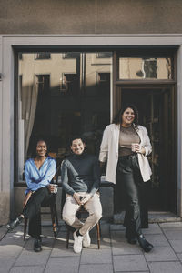 Portrait of smiling multiracial male and female business colleagues outside office