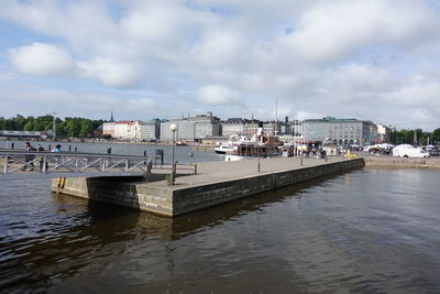Pier in river with city in background
