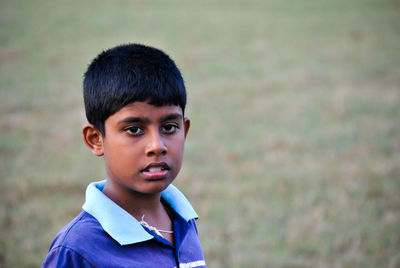 Portrait of teenage boy standing in field