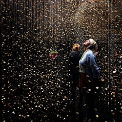 Man and woman standing by illuminated lights at night