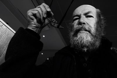 Low angle view of senior man holding eyeglasses